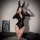 A woman poses wearing a glossy vinyl catsuit with bunny ears, featuring a deep v-neckline and long sleeves. the bodysuit has ...