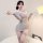 Woman wearing a sheer, deep v lace bodycon sleep dress with long sleeves and thigh-high stockings.