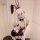A person wearing a bunny-themed cosplay outfit featuring a black lace-up dress with pink bunny ears, white gloves, and stocki...