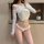 Elegant white lace cross-back thong bikini with bow detail, perfect for a sensual and chic look.
