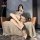 A stylish woman poses on a cozy chair wearing night sensual open-crotch pantyhose set, featuring nude stockings and garter ...