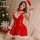 A woman poses in a festive red christmas dress with white fur trim, featuring a santa hat and choker, perfect for holiday-the...