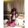 A woman poses playfully wearing an adorable hello kitty maid costume set, featuring a cute dress with polka dots and a bow he...