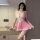 Woman wearing pink and white maid-style lingerie set with lace trim, headband, choker, and thigh-high stockings.