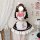 A woman wears an adult womens cosplay maid dress, featuring a black and white design with pink accents. the outfit includes a...