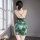 Elegant green floral design, high-waist silhouette, pearl embellishments, sensual vintage qipao dress with back cross detail.