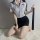Woman kneeling in white shirt and black skirt, holding tie, wearing airu airu sexy flight attendant costume for women - polic...