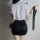 Woman wearing airu airu sexy flight attendant costume with white blouse and black skirt, holding a tie.