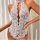 Sheer lace lingerie bodysuit with floral trim, deep v-neck and open back – sexy intimate sleepwear for women.