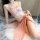 Vintage-inspired pink silk bodysuit adorned with floral embroidery, paired with flowing peach fabric for an elegant and playf...