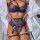 Woman wearing navy lace lingerie set with garter straps and open robe, showcasing elegant seductive design.