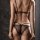 Back view of woman wearing elegant black lace thong set, featuring sheer fabric and delicate straps.