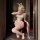 A woman poses in a bunny costume featuring a sheer open-crotch bodysuit with lace details and bunny ears, perfect for role pl...