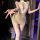 Woman wearing bird moon lace sheer lingerie set with bodycon skirt and lace details, posing seductively in a dimly lit room.