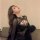 Woman wearing black lace lingerie set with padded cups, sheer sleeves, and open-crotch design for small busts.