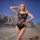 A woman poses confidently against a desert backdrop wearing a black lace sexy lingerie set, featuring intricate designs and a...
