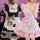 Two women wearing black and white cat girl cosplay costumes, featuring maid outfits with paw prints, ruffled sleeves, and bow...