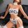 Woman wearing black and white cow print lingerie set with lace trim, push-up bikini top, garter belt, and matching choker.