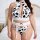 Woman wearing black and white cow print lingerie set with lace trim, push-up top, and garter belt straps.