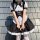 A woman wears a black and white gothic lolita maid dress with ruffles, buttons, and a bow tie, perfect for halloween costumes...