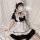A woman poses wearing a black and white maid dress, featuring ruffled sleeves and collar, perfect for cute lolita cosplay or ...