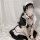 A woman wearing a black and white maid dress, featuring ruffled sleeves and collar, perfect for cute lolita cosplay or plus-s...