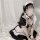 A woman wearing a black and white maid dress, featuring puffed sleeves and ruffled details, perfect for cosplay or lolita fas...