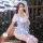 A woman poses in a blue grid maid costume featuring a checkered top, skirt, and stockings, perfect for role play or bedroom f...