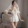 Woman wearing a white bridal lingerie set with lace details and a veil, embodying a sweet and innocent princess style for wed...