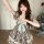 A charming woman poses in a vintage-inspired dress featuring a plaid pattern, lace-up waist, and a-line skirt design, perfect...