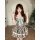 A charming woman poses in a vintage-inspired dress featuring a plaid pattern, lace-up waist, and ruffled skirt, perfect for s...