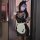 Woman wearing black bunny girl cosplay costume with white apron, bow tie, and ears, holding phone in mirror selfie.