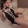 Woman wearing black bunny girl lingerie bodysuit with white lace trim, front ties, and open-crotch design.