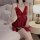 Woman wearing red butterfly lace sleep dress with bow detail, sheer back, sitting on bed holding rose – romantic spring linge...