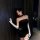 Woman modeling black butterfly rain lingerie set with crop top, bodycon skirt, white gloves, and bow detail.