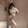 Woman in white bunny costume with sheer cut-out top, open-crotch design, and fluffy tail accessory.