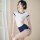 A woman poses wearing a white and navy campus sexy womens sleepwear set featuring a cute and spicy short sleeve tie-front bod...