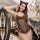 Woman wearing hot cat-themed sexy lingerie bodysuit with leopard print, black fishnet mesh, and cat ears in elegant setting.