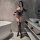 Woman in bathroom wearing sexy leopard print catwoman bodysuit with lace sleeves, garter belt, and thigh-high stockings for r...