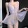 Woman wearing lavender lace lingerie set with sheer mesh sleep dress, featuring delicate straps and polka dot details.