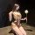 Woman wearing chao mu lingerie set, a sexy backless bodysuit with bow tie and ruffle trim, holding a dandelion.