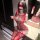 Woman wearing red sheer mesh bodysuit with lace details, featuring a seductive design and eye mask.