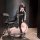 Woman in black chao mu qing qu mesh bodysuit with cutouts, lace-up sides, thigh-high stockings, and heels, posing beside a ch...