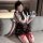 A stylish schoolgirl outfit featuring a plaid skirt, suspenders, and a tie, paired with thigh-high stockings adorned with bow...