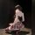 Woman wearing chao mu sensual lingerie set with red plaid jk skirt, black stockings, and high heels, posing in a dimly lit ro...