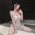 Woman wearing chao mu sexy corset vest — lace bodysuit with sheer panels, garter straps, and alluring silhouette on bed.