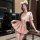 A stylish woman poses in a chic pink jk-style outfit featuring a flirty pleated skirt and matching bra, perfect for luxury se...