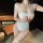 Woman wearing a charming lace sheer chemise set with push-up bust and open-crotch design, flirty and feminine sleepwear.