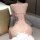Woman wearing a pink cherry blossom lace bodysuit with heavy embroidery and a deep v plunge back, featuring delicate mesh cam...