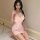 Woman wearing pink cherry blossom lace babydoll nightgown with thin straps, posing indoors on marble floor.